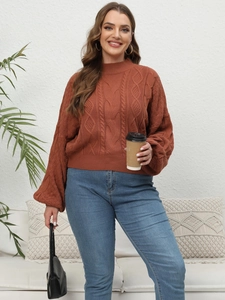 Detail view of terracotta cable knit sweater texture and relaxed fit on model