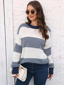 Gros plan d'un pull en maille à rayures horizontales bleues et blanches avec poignets