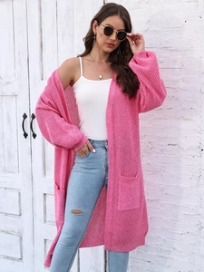 Dettaglio del cardigan lungo rosa acceso con grandi tasche e trama a maglia spessa