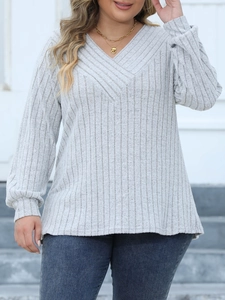 Detailed view of grey rib-knit V-neck top featuring a stylish crossover design