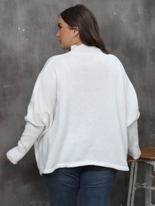 Detail view of the white batwing sleeve sweater back showing loose knit texture and mock neck
