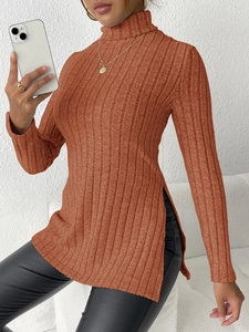 Detail of caramel ribbed knit sweater featuring high side slits and a turtleneck design