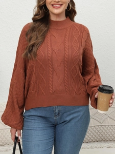 Close-up of brick red cable knit sweater with puff sleeves and textured stitch detail