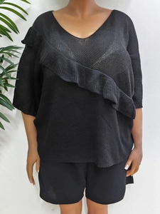 Women's loose black V-neck knit top with diagonal ruffle detail and half sleeves