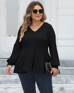 Detail view of V-neck plus size black ribbed knit top with long lantern sleeves on model
