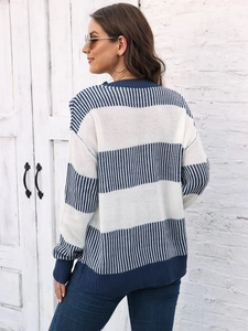 Détails de la maille rayée bleue et blanche et poignets côtelés sur le pull ample