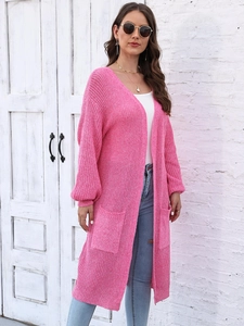 Dettaglio del cardigan lungo rosa con trama a maglia grossa e grandi tasche quadrate