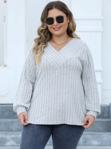 Detail of light grey ribbed knit texture and cross V-neckline on women's casual top