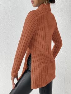 Detail view of side slit design on a caramel orange ribbed turtleneck knit sweater for women