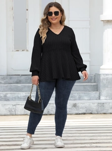 Close-up of black V-neck tunic with vertical ribbed texture and long lantern sleeves
