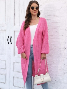 Dettaglio del cardigan lungo rosa con trama in maglia grossa e ampie tasche laterali