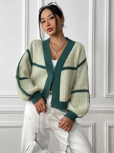 Detail of color-block knit cardigan featuring lantern sleeves and ribbed cuffs