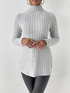 Close-up of light grey turtleneck sweater featuring ribbed texture and slim fit design