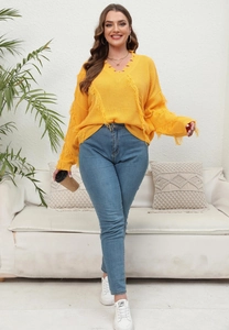 Detail of bright yellow V-neck knit sweater with fringe stitching and casual styling