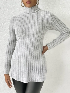 Detailed texture of grey high-neck ribbed knit sweater with side split on slim-fit hem