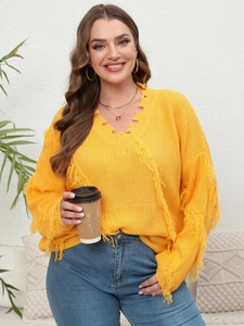 Detail of yellow V-neck knit sweater with trendy fringe patchwork and distressed hem