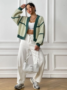 Women's green striped knit cardigan with white crop top and high-waisted wide-leg trousers
