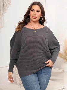 Detail of dark grey knit sweater showing horizontal ribbing texture and batwing sleeves