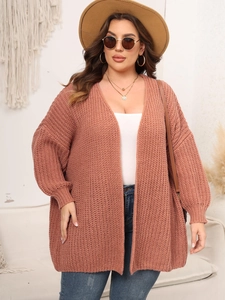 Detailed close-up of coarse knit texture on a brick red long sleeve cardigan