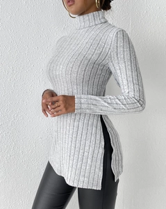 Detail of light gray ribbed knit sweater with high neck and unique side slit design