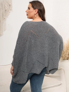 Detail eines dunkelgrauen Strickponchos mit einzigartigem V-Ausschnitt am Rücken