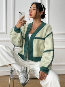 Detail of loose knit cardigan texture with cream and dark green stripes