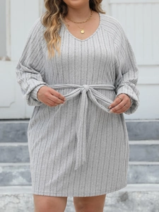 Detailed texture of grey ribbed knit fabric on a V-neck long sleeve dress with waist tie