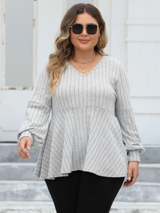 Detail of grey V-neck ribbed blouse with lantern sleeves and ruffled hem silhouette