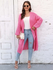 Dettaglio della trama a maglia grossa e delle grandi tasche sul cardigan rosa