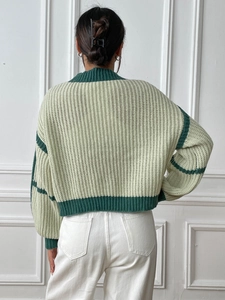 Macro view of chunky knit texture and color-block stitching on the sweater sleeve