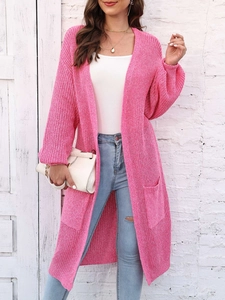 Dettaglio del lungo cardigan rosa in maglia con grandi tasche laterali e trama spessa