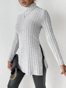 Detail view of high turtleneck and ribbed knit texture on a slim grey sweater with side slits