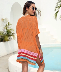 Detail of orange crochet beach cover-up with vibrant colorful striped hem and side slits