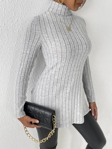 Detail view of women's turtleneck ribbed sweater with side split and slim fit style
