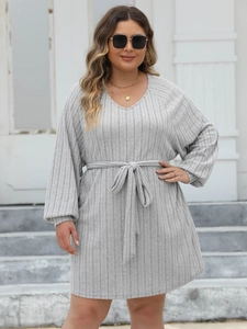 Detail of grey ribbed knit dress featuring a V-neckline and adjustable waist tie