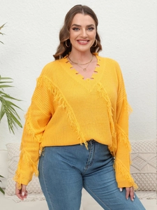 Detail of a bright yellow V-neck knit sweater with bohemian fringe and distressed texture