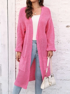 Dettaglio del cardigan lungo in maglia rosa chiaro con grandi tasche e trama a rilievo