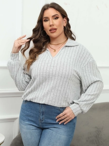 Detail view of light grey ribbed knit texture and V-neck polo collar on women shirt
