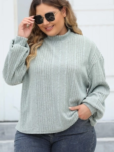 Detail of light grey-green ribbed knit texture on a plus size mock neck long sleeve top