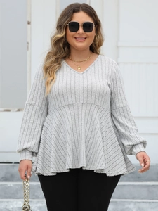 Detail of grey ribbed V-neck tunic with balloon sleeves and peplum waist styling