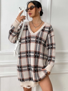 Detail of V-neck plaid sweater dress featuring frayed edges and contrast color pattern