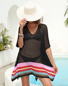 Detail of crochet beach cover-up with V-neck and colorful striped hem in sunny poolside setting