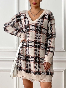Detail of V-neck plaid knit dress featuring distressed hem and soft autumn colors
