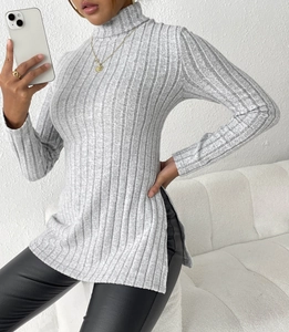 Close-up of light gray ribbed knit turtleneck top featuring a stylish side slit detail
