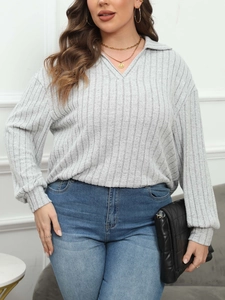 Detail of light grey ribbed knit polo top with V-neckline and dropped shoulder sleeves