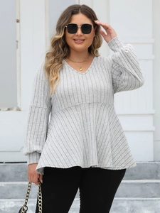 Detail of light grey V-neck peplum top with ribbed texture and lantern sleeves
