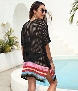Detail of black crochet beach cover-up featuring colorful striped hem and side slits