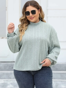 Detailed view of the mock neck design and ribbed knit texture on this sage green top