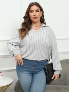 Detailed view of women's ribbed knit polo shirt featuring a V-neck and lantern sleeves