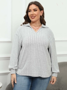 Women's grey long sleeve polo neck ribbed knit top paired with blue skinny jeans